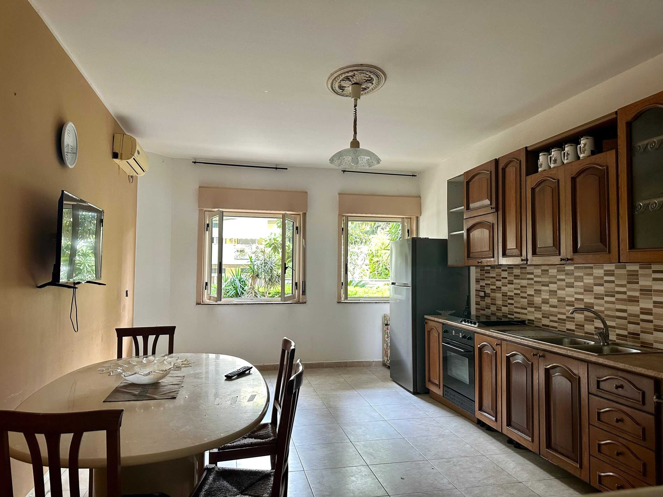 Lavagna con finestra aperta e cucina abitabile in stile classico con mobili in legno, piano cottura e frigo, ambienti luminosi e spaziosi, ideale per ogni famiglia.
