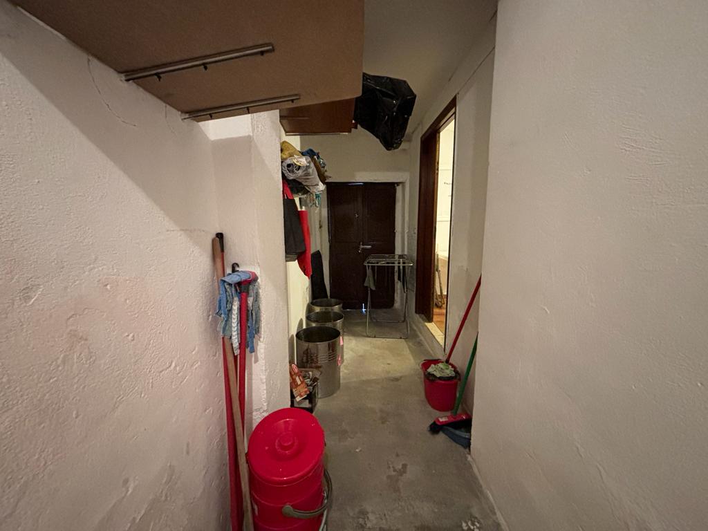 Scaffale per la casa e attrezzi per la pulizia in un ingresso di un appartamento di NextCasa.