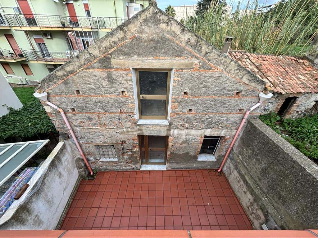 Antica casa in pietra con terrazza, ristrutturata, situata nel centro storico con camini e tetto in terracotta, ideale per investimento immobiliare o ristrutturazione.