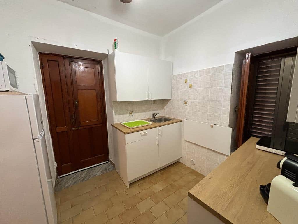 Agenzia immobiliare NextCasa, appartamento con cucina compatta e spazio funzionale, dotata di lavandino, frigorifero e forno. Ambienti arredati in stile semplice e pratico, ideale per uso abitativo o investimento immobiliare.