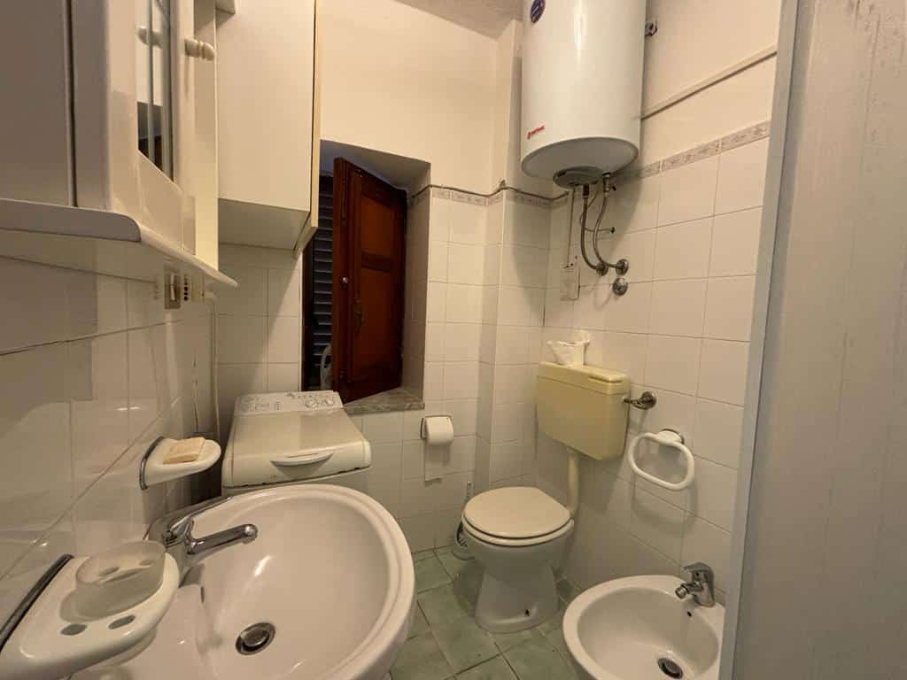 Lavabo con sanitari e anni di finestre, bagno pratico con water, bidet e scaldabagno, ideale per appartamenti NextCasa, soluzione compatta e funzionale per la casa.