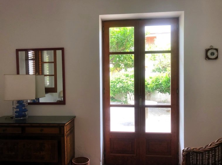 Porta in legno con vetri per interni ed esterni, design classico e funzionale, illuminata dalla luce naturale, ideale per case e appartamenti rustici o moderni a Roma.