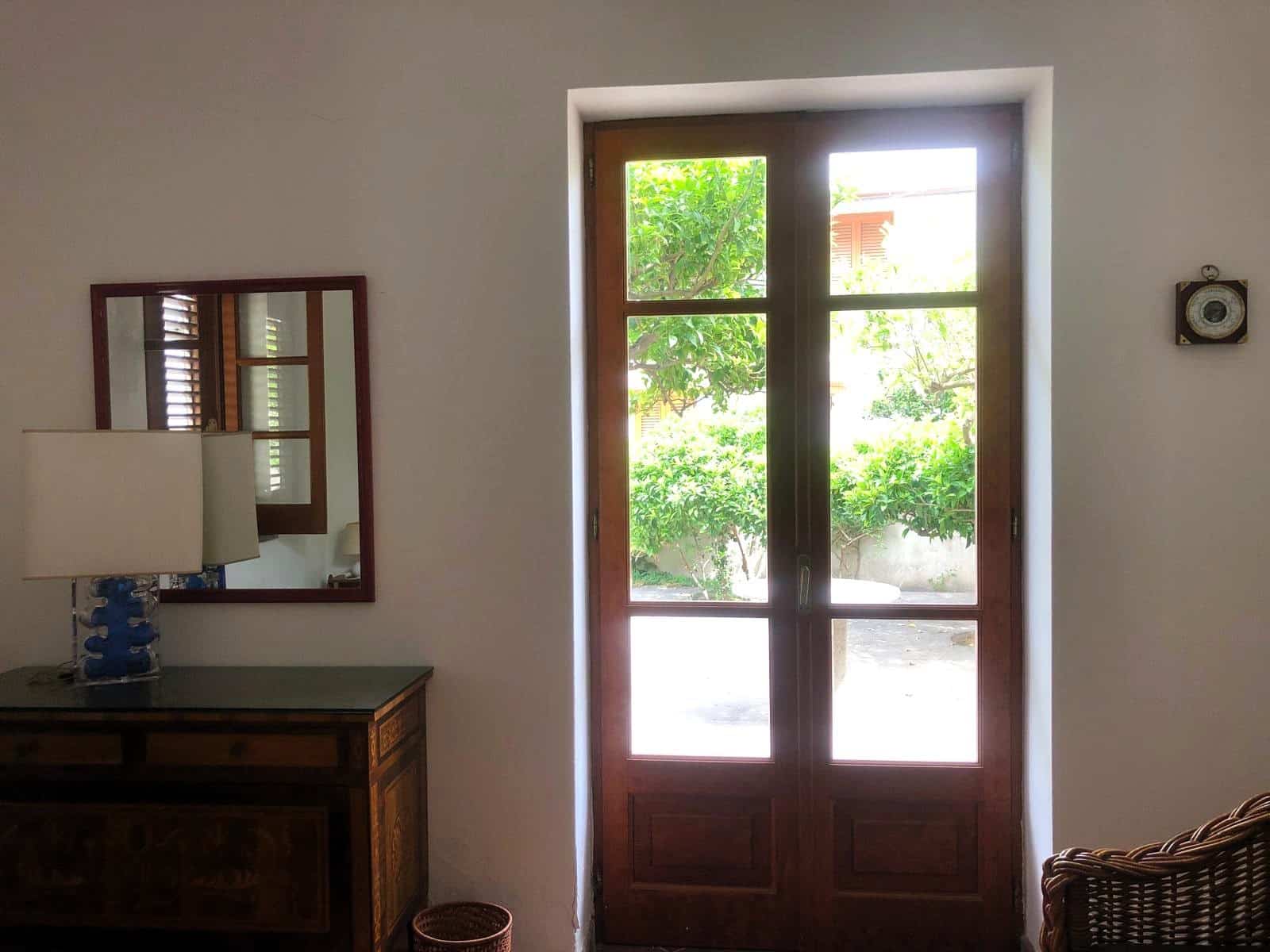 Porta in legno con vetri per interni ed esterni, design classico e funzionale, illuminata dalla luce naturale, ideale per case e appartamenti rustici o moderni a Roma.