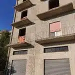 Finestra con grate in edificio residenziale, facciata rustica, dettagli di infissi e balconi, rappresenta l'immobiliare per la vendita o affitto di case.
