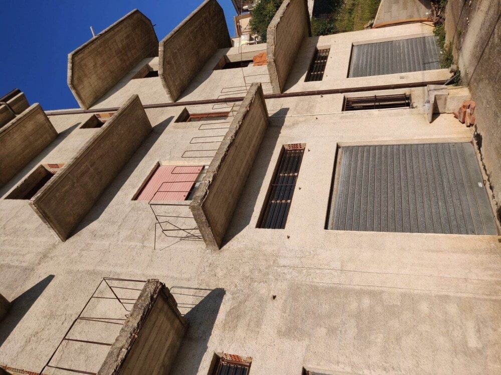 Appartamenti in costruzione con balconi e finestre con grate di sicurezza, in fase di completamento, periferia urbana, edilizia moderna Italia, processo di sviluppo immobiliare.