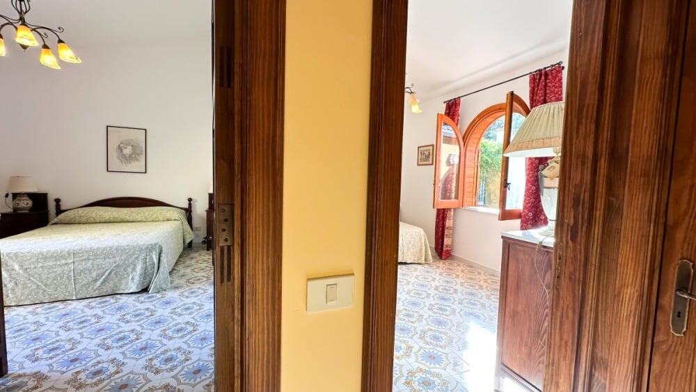 Camera doppia rustica con arredi in legno, dettagli classici e atmosfera accogliente, ideale per soggiorni in bed and breakfast o affitti brevi in Italia.