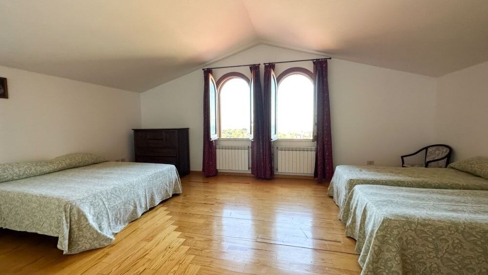 Ampio soggiorno con due letti singoli e una camera matrimoniale in ambiente tranquillo e luminoso, ideale per affitti di breve e lungo termine, con vista panoramica e arredi funzionali.