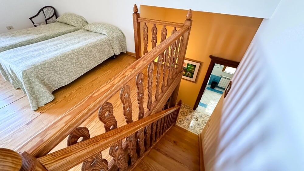 Accoglienza stanza da letto con parquet in legno, vista sulla scala in legno, arredamento classico, atmosfera calda e confortevole.