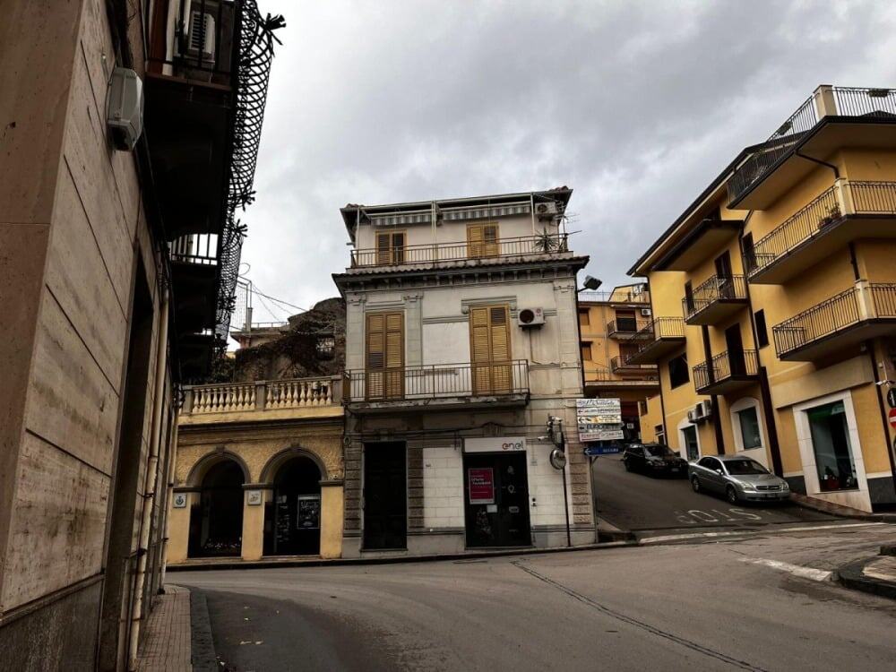 Autofficina in strada con edifici residenziali, dettaglio di case storiche e moderne vicino a un'area urbana, rappresenta opportunità di investimento e di servizi per la comunità locale.
