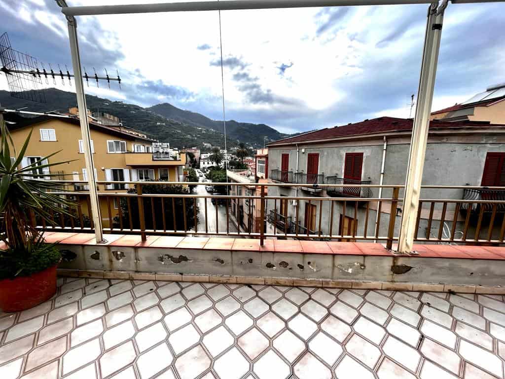 Balcone con vista panoramica sulle case e le montagne, illuminato dalla luce naturale, ideale per attività all'aperto e relax, vicino a servizi e zone residenziali di NextCasa.