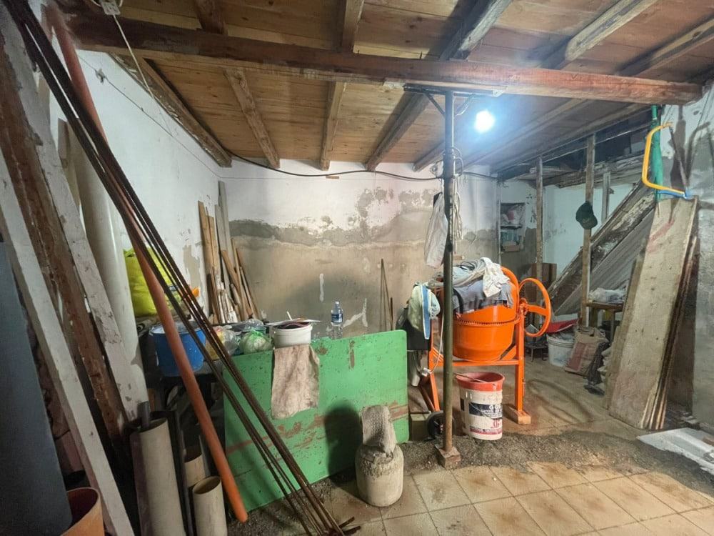 Materiali ed attrezzi da costruzione e ristrutturazione in uno spazio di lavoro temporaneo. Ferri, betoniere, cemento e pannelli di legno disponibili per lavori di muratura ed edilizia domestica.