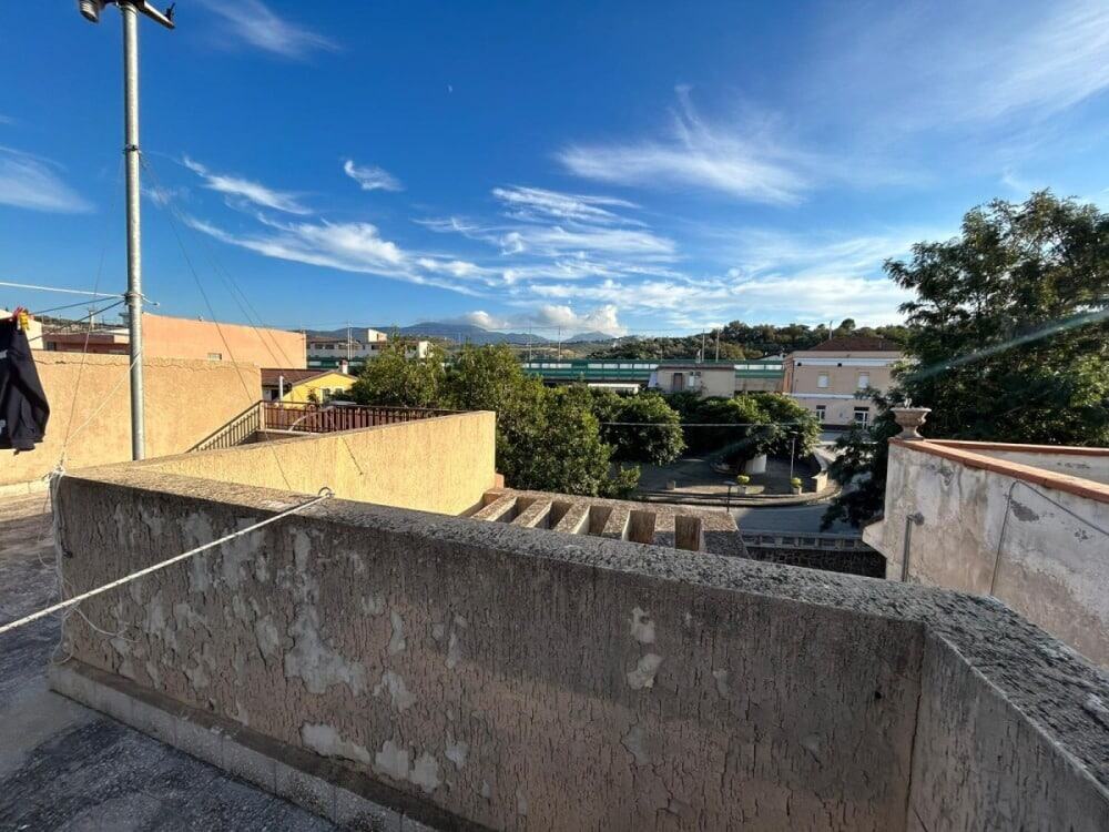 Vista panoramica di un terrazzo con cielo azzurro e nuvole bianche, in un quartiere residenziale. Ideale per immagini di immobili, case e proprietà immobiliari NextCasa, con forte focus su immobili panoramici.