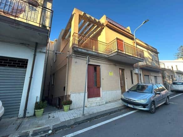 Vecchia casa indipendente in zona residenziale con parcheggio auto, balconi e facciata in stile tradizionale, situata in via tranquilla vicino a servizi e aree verdi, ideale per investitori e famiglie.