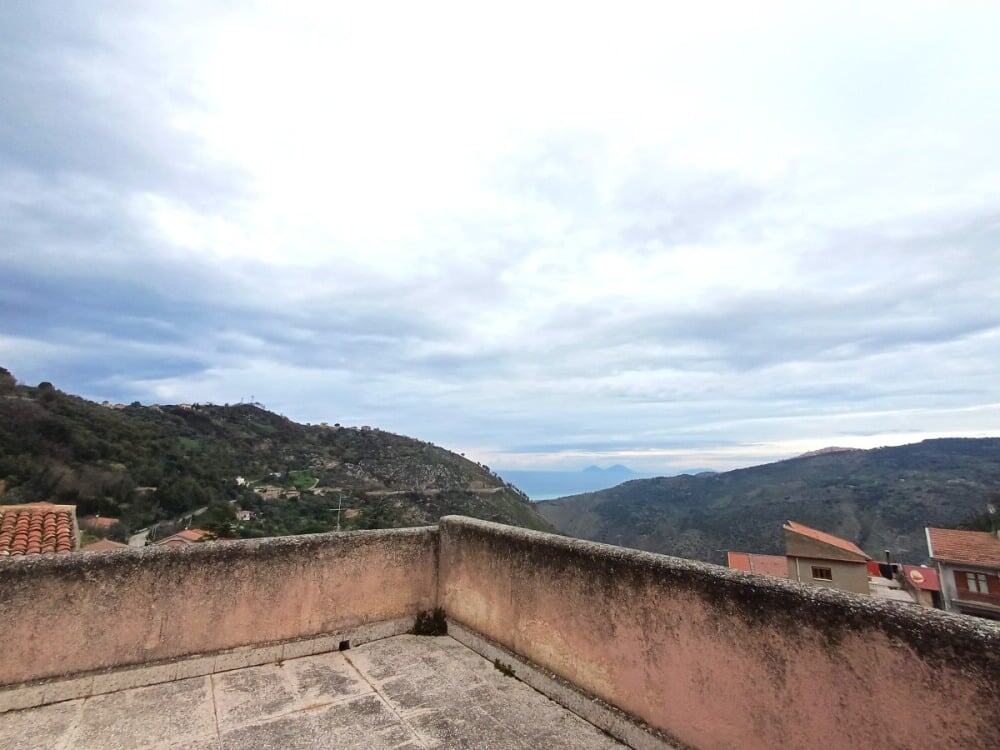 Vasta terrazza con vista panoramica sulle colline e il mare, ideale per relax e convivialità in contesti residenziali di charme.
