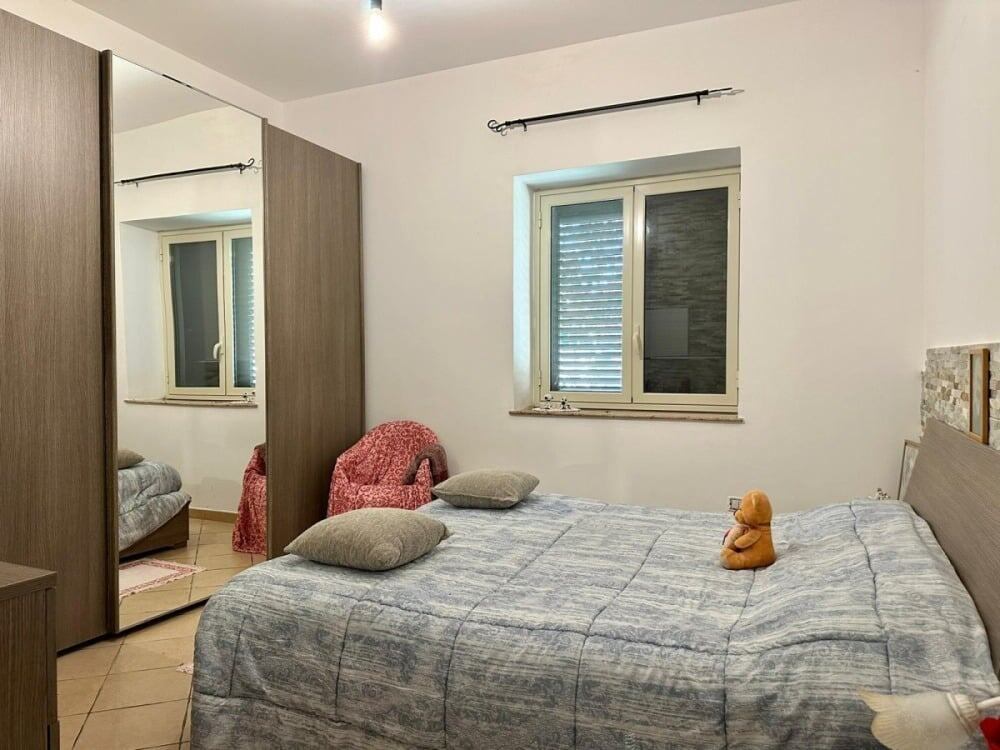 Letto matrimoniale camera da letto con finestre, armadio a specchio, arredi moderni, ambiente tranquillo e accogliente, camera principale di proprietà residenziale a Roma.