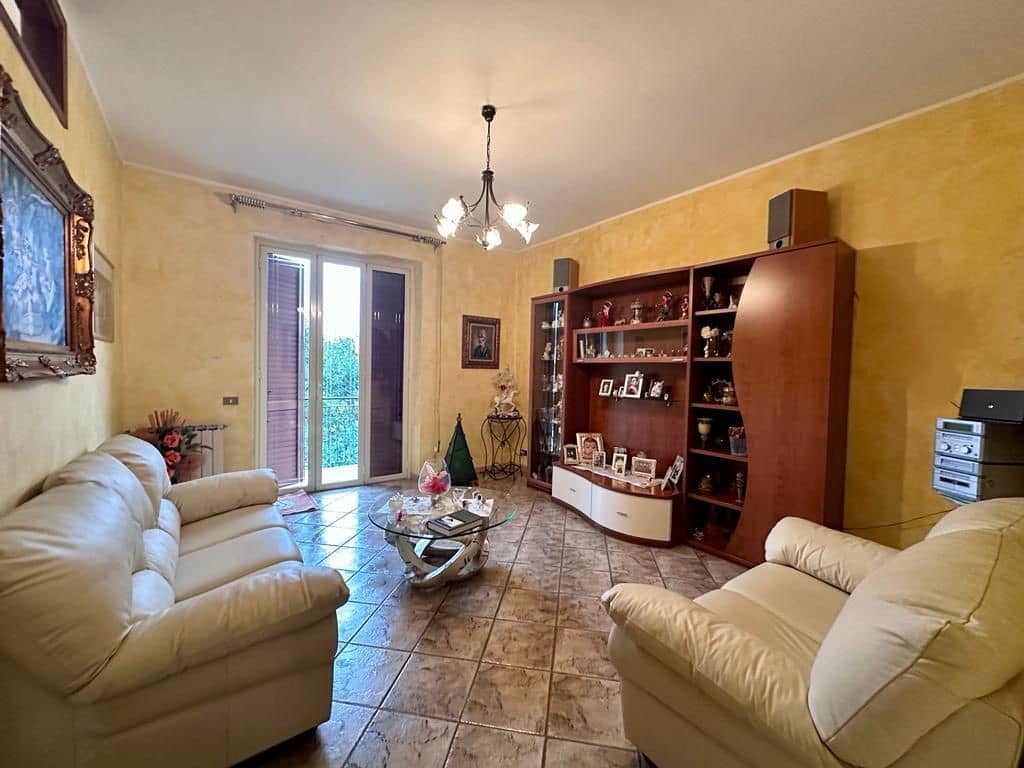 - Elegante soggiorno con divani in pelle beige, pareti gialle e arredamento in stile classico, ideale per vivere momenti di relax e ospitare amici in un ambiente accogliente.