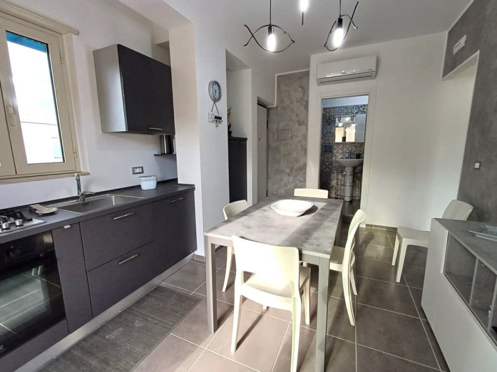 Lavastoviglie moderna e cucina completamente attrezzata in appartamento NextCasa, con zona pranzo elegante e aria condizionata. Perfetto per vivere confortevolmente in spazi funzionali e di design.