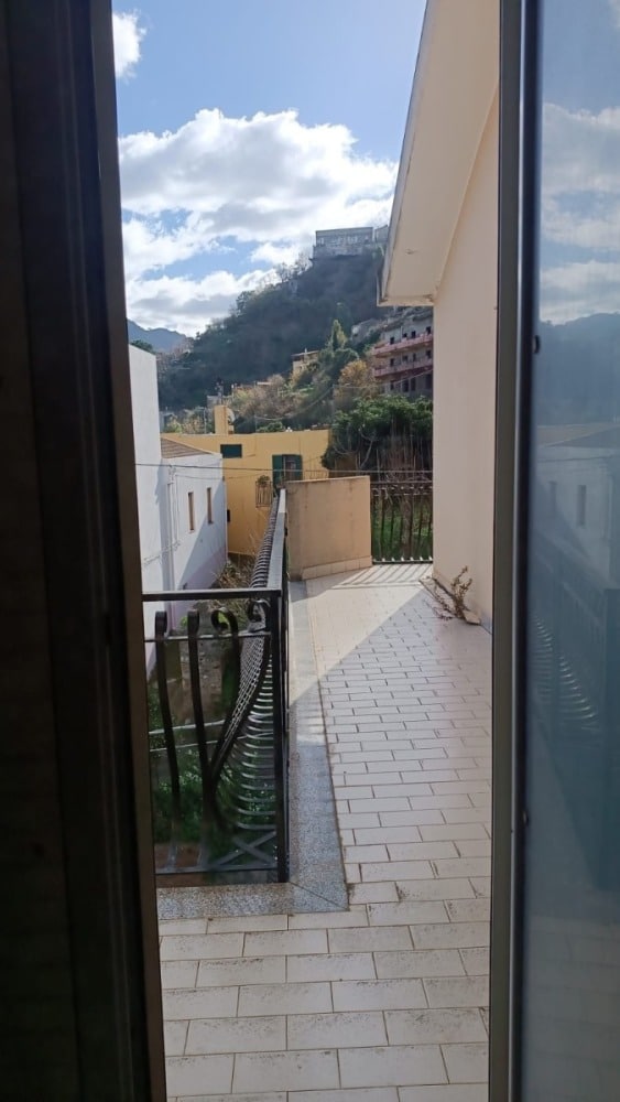 Balcone con vista panoramica sulla città e la natura circostante, illuminato dalla luce naturale, perfetto per relax e godersi l'aria aperta in un ambiente tranquillo.