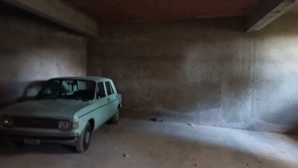 Auto d'epoca in garage con pareti in calcestruzzo, spazio ideale per il deposito e la manutenzione, in un ambiente sicuro e funzionale.