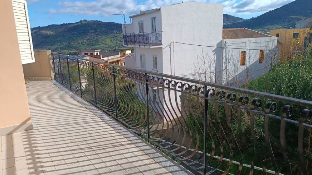 Balcone con ringhiera in ferro battuto e vista panoramica su case e montagne in Calabria, Italia. Perfetto per immobili residenziali o investimento immobiliare, con ambiente esterno spazioso e panoramico.