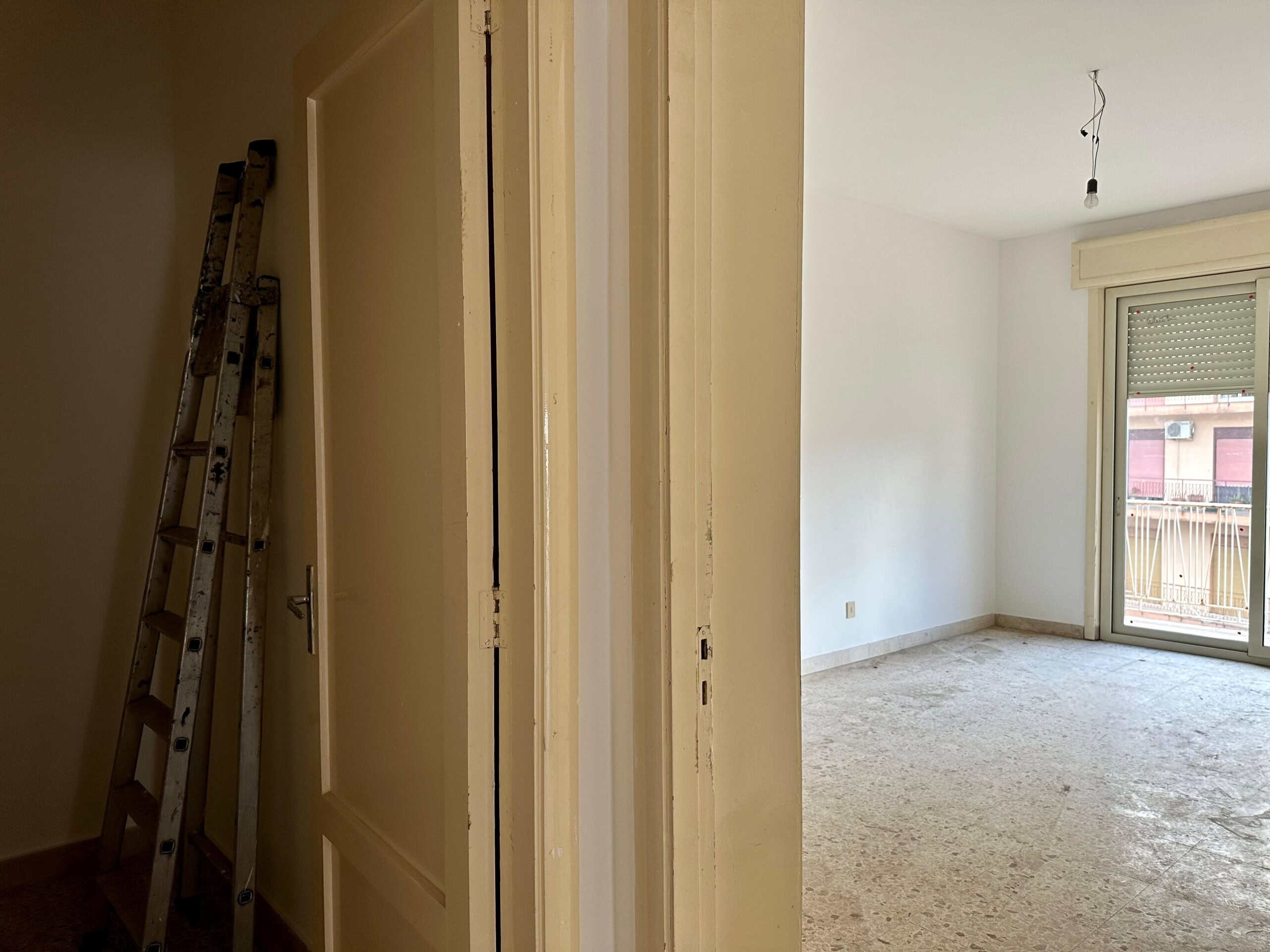 Immagine di un appartamento in fase di ristrutturazione con pareti bianche e grande balcone con porta scorrevole, perfetto per investimenti immobiliari o abitare a Torino.