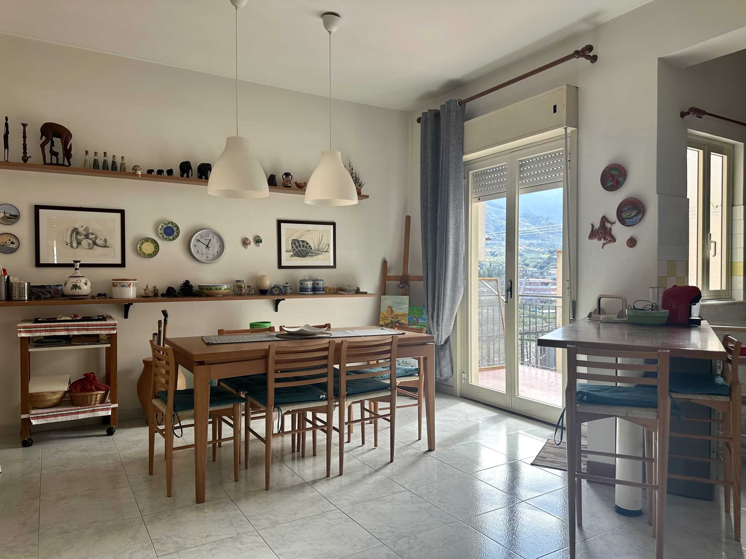 Elegante sala da pranzo con tavolo in legno, grande finestra con vista sulla città e decorazioni artistiche alle pareti, in uno stile accogliente e luminoso, ideale per abitazioni di design.