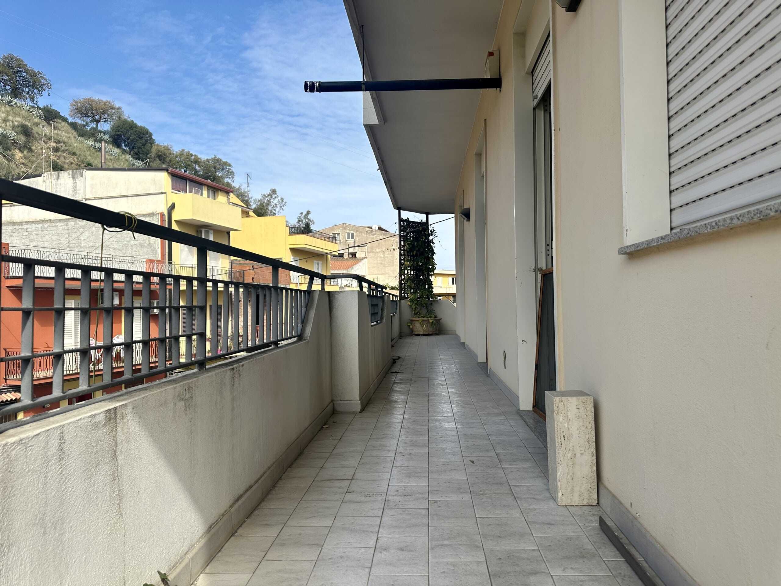 Balcone spazioso e luminoso con vista sulle case colorate e la natura circostante, ideale per relax e godersi l'aria aperta.