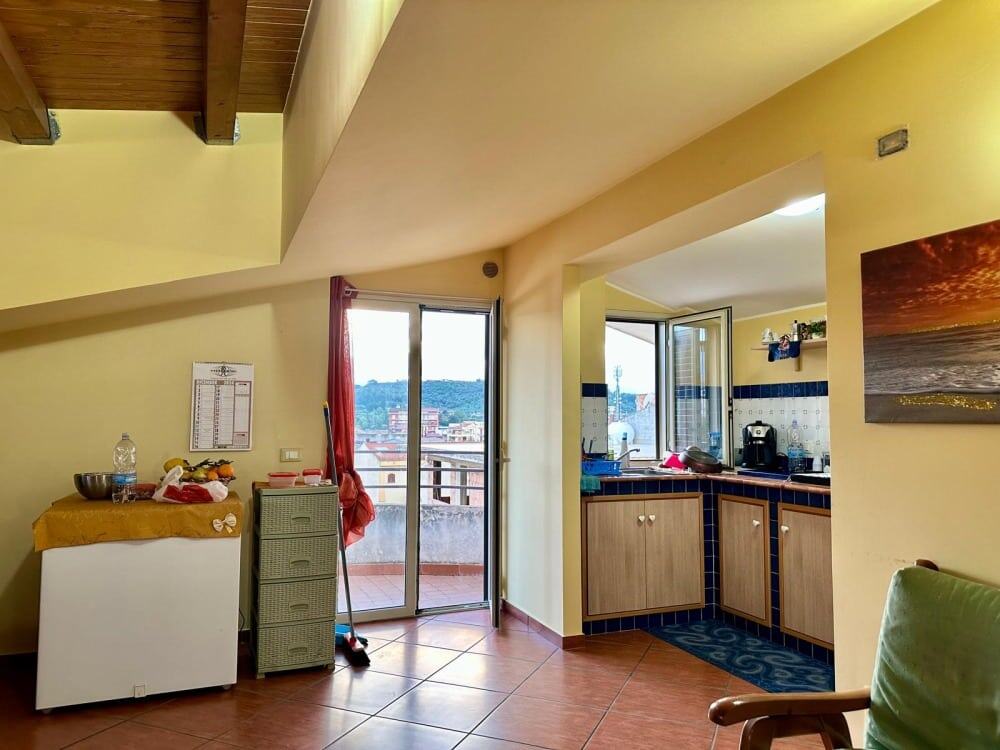 Scorcio cucina e balcone con vista sulla città e colline, interni luminosi e accoglienti, arredi pratici e moderni, ideale per living in Italia, NextCasa immobiliare.
