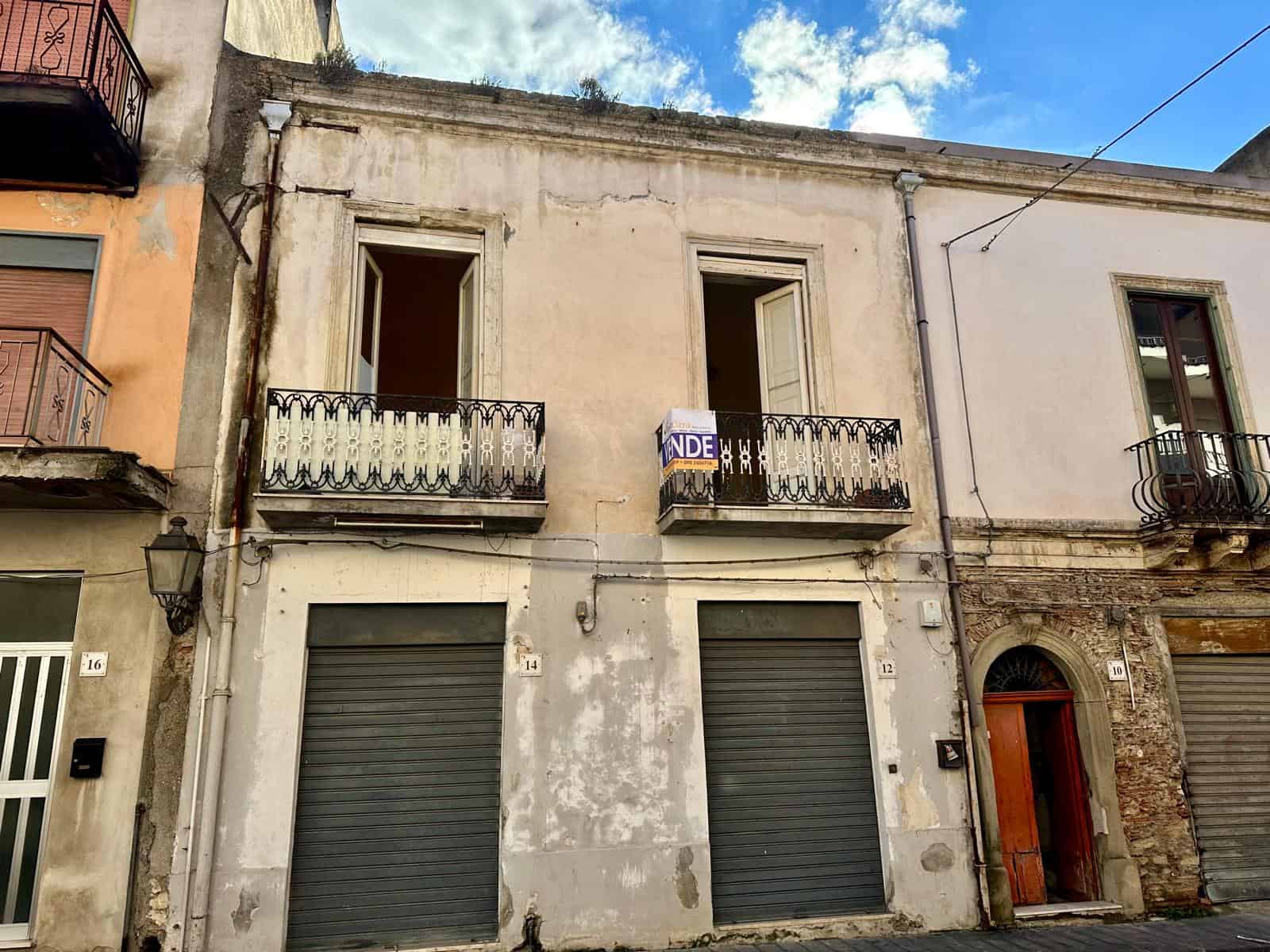 Appartamento con bottega Vecchia casa con balconi e finestre senza infissi, in posizione centrale, in stato di abbandono e pronto per ristrutturazione, con negozio al piano terra, situata in un affascinante quartiere storico.