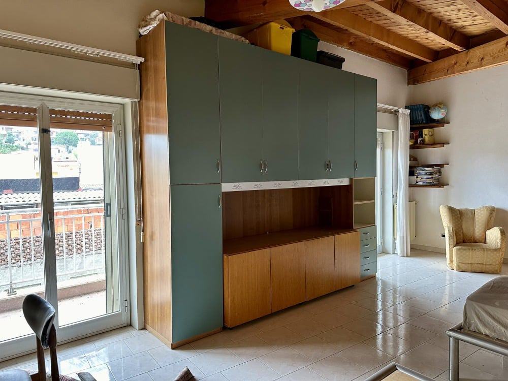 Armadio a muro in soggiorno con spazio snack, arredamento rustico con soffitto in legno.