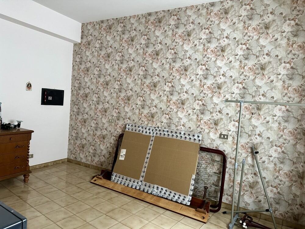 Pannello decorativo e mobilio in una stanza di casa con parete a fiori in stile vintage NextCasa.