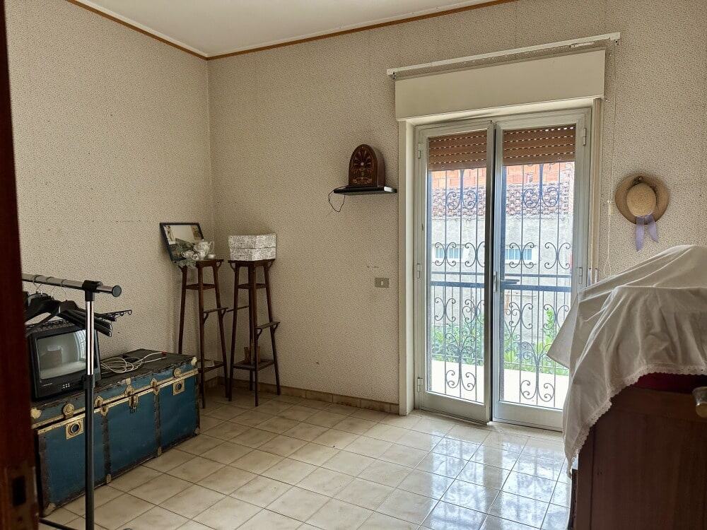 Finestra doppia con inferiate e vista sul balcone in un appartamento in affitto a NextCasa, con pareti neutre e arredamento semplice.