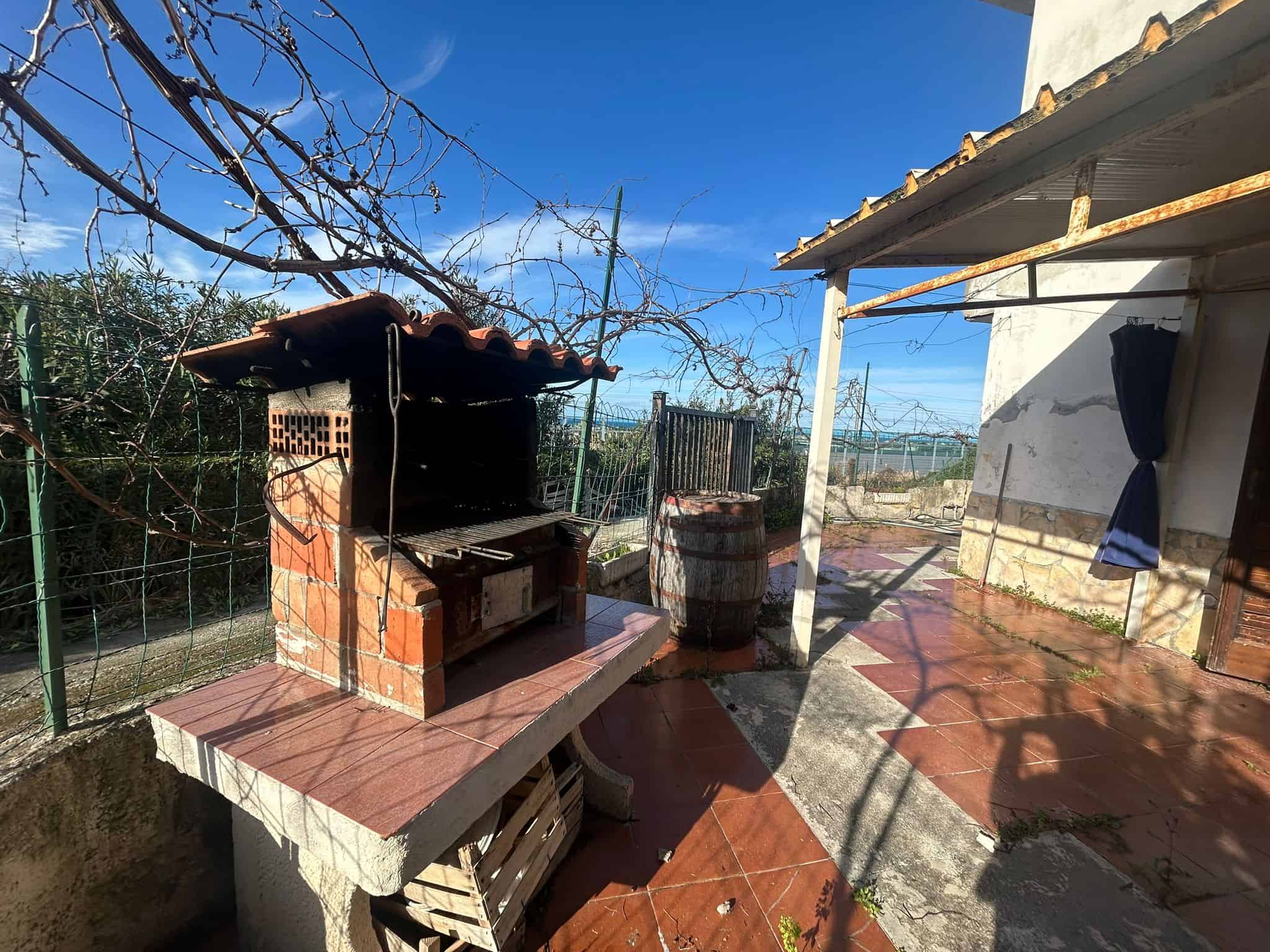 Forno a legna in giardino con tetto in tegole, area esterna con pavimentazione in gres rosso, eccellente spazio esterno per barbecue e cene all'aperto, vista campagna, atmosfera rustica e accogliente.