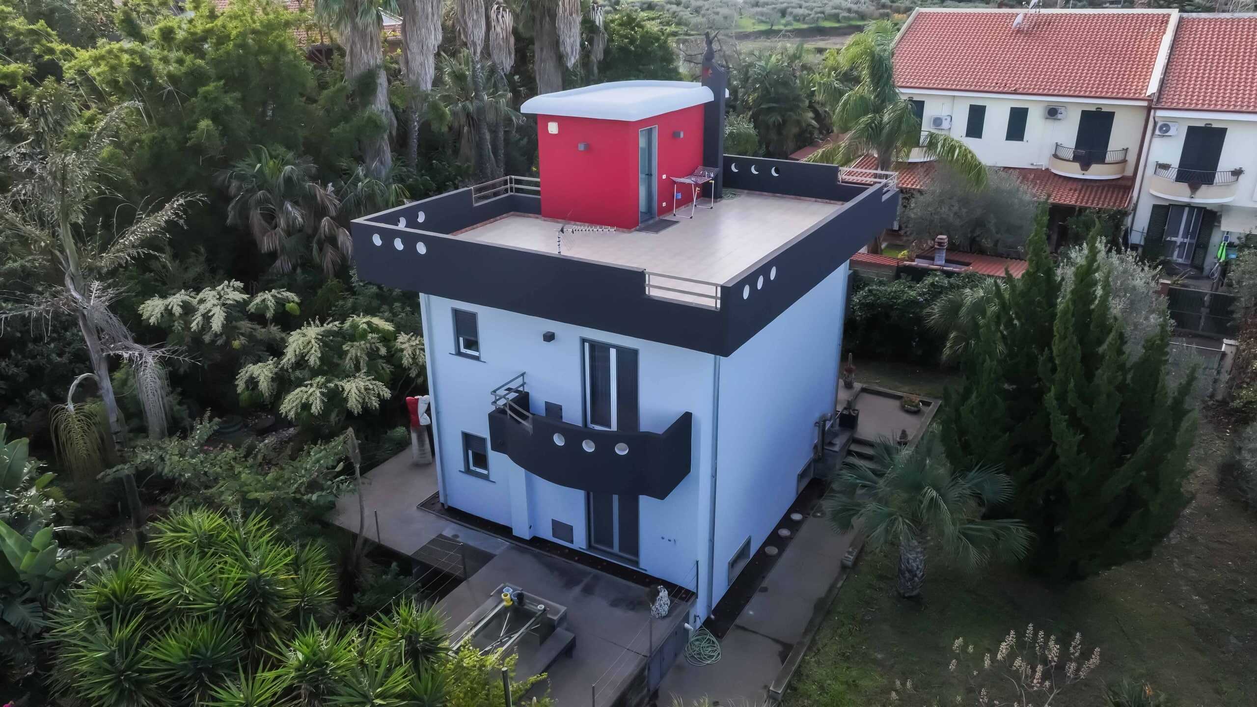 Vista aerea di una villa moderna con terrazza panoramica e giardino immerso nel verde, perfetta per investimenti immobiliari e case di design in zona residenziale.