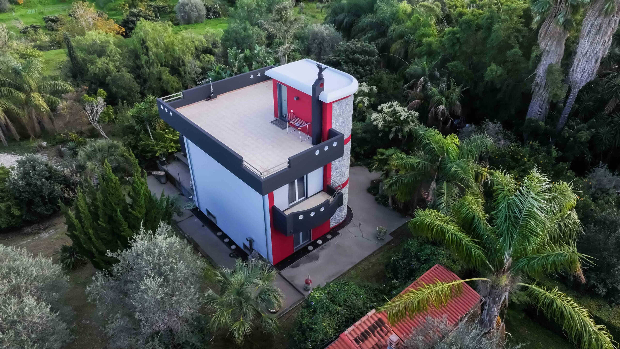 Moderno edificio residenziale con terrazza panoramica in un'area verde rigogliosa, immerso nella natura, con design contemporaneo e struttura elegante, ideale per vivere in tranquillità.