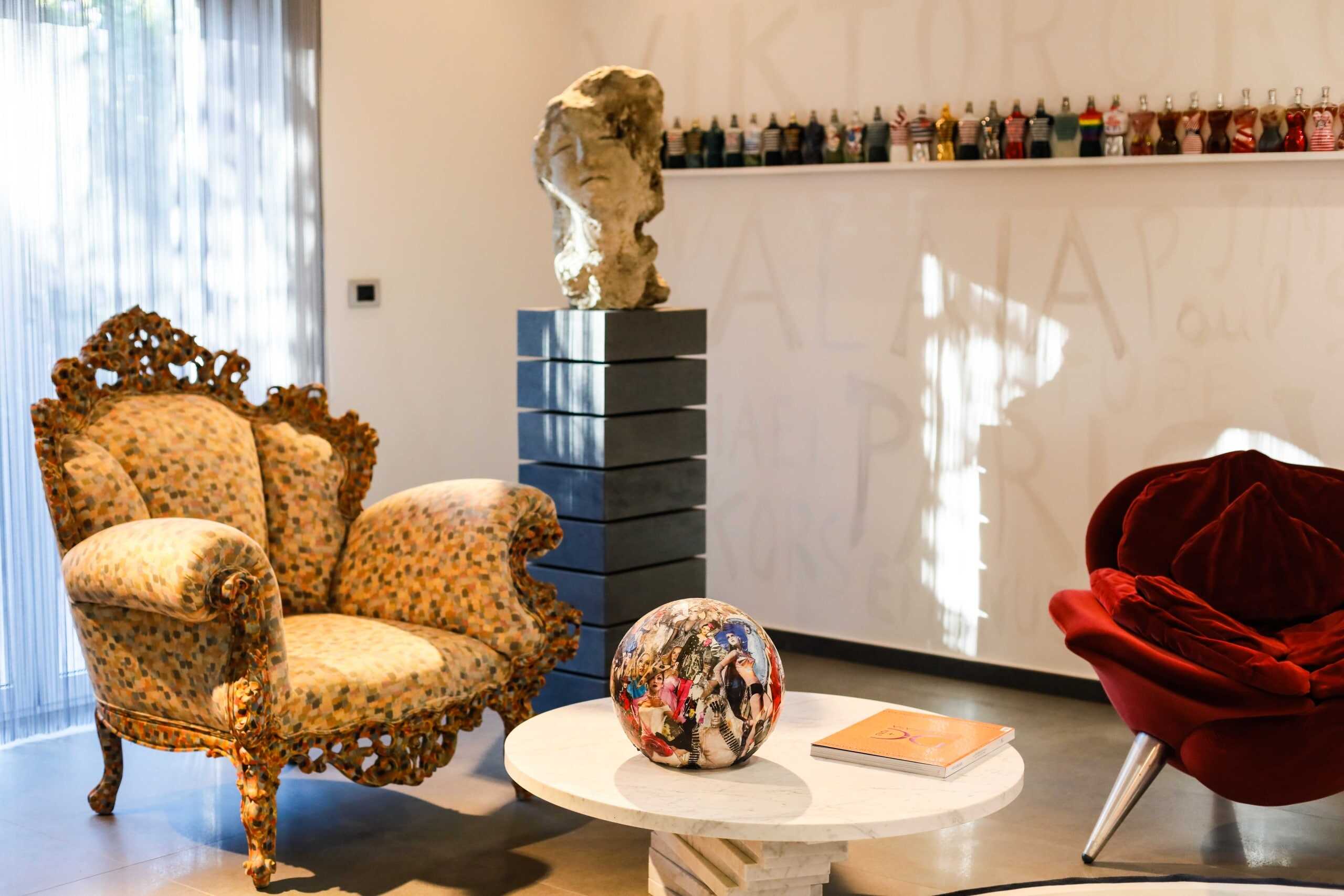 Sedie e divani di design con arredamento moderno, pezzi unici e opere d'arte in uno spazio accogliente e di alta qualità, ideale per gli amanti dell'interior design e del comfort elegante.