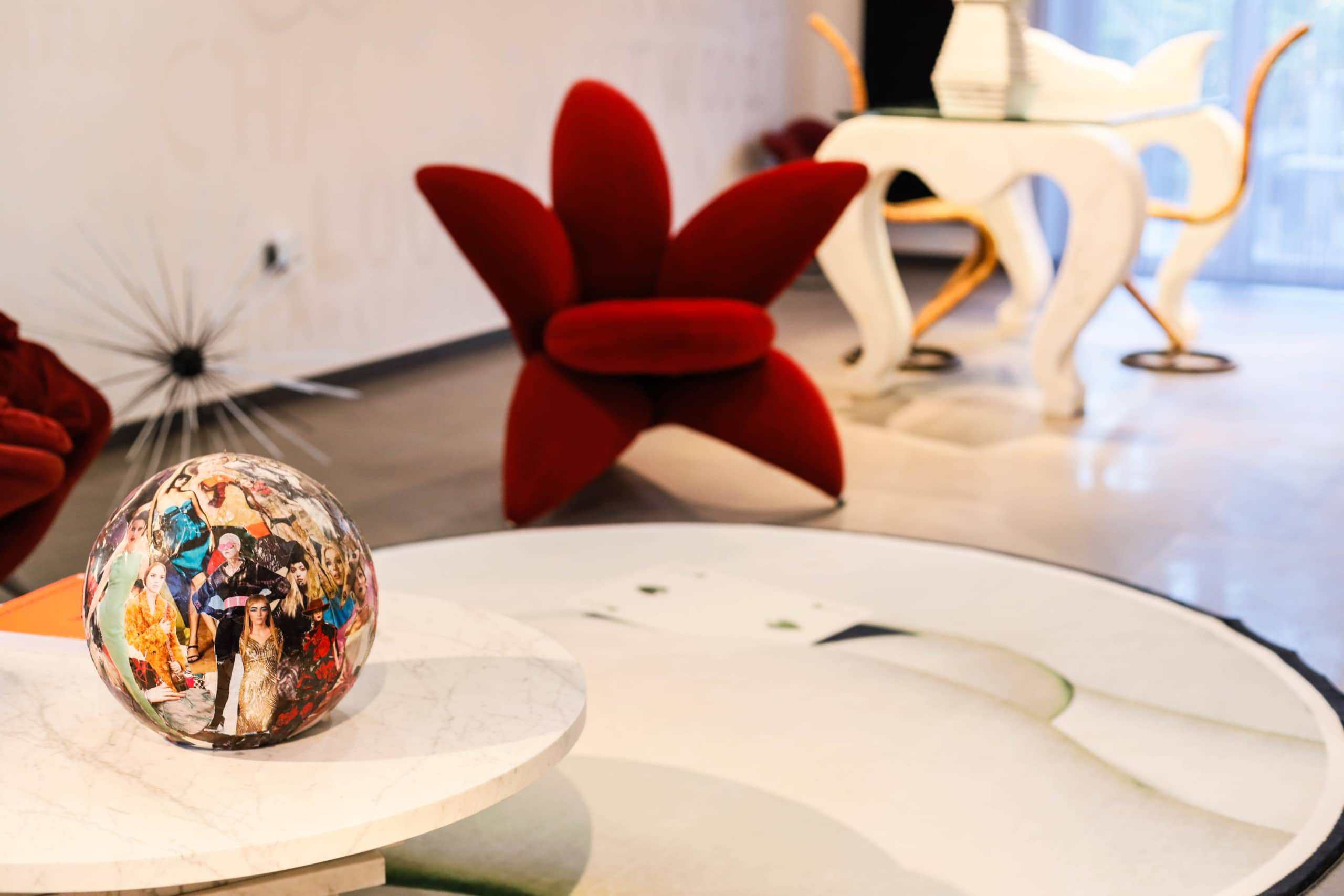 Vetro decorativo con immagini di moda, posizionato su tavolino in marmo bianco in uno showroom di arredamento.