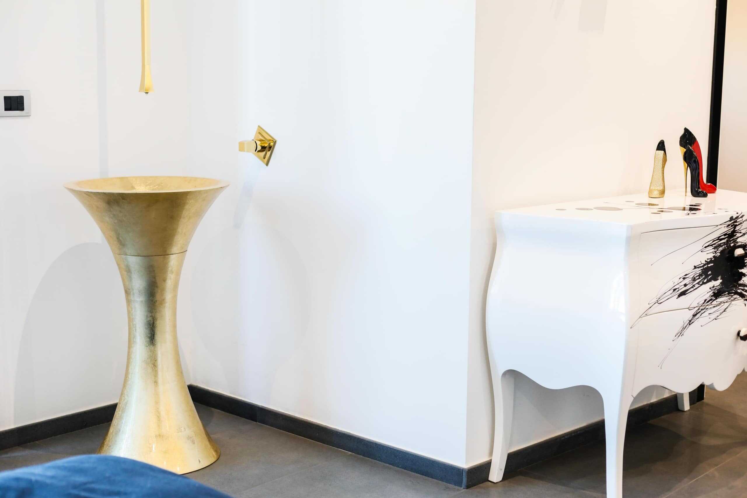 Elegante console bianca con design curvato e decorazione moderna, perfetta per valorizzare l'arredamento di casa o ufficio, abbinata a accessori di stile.