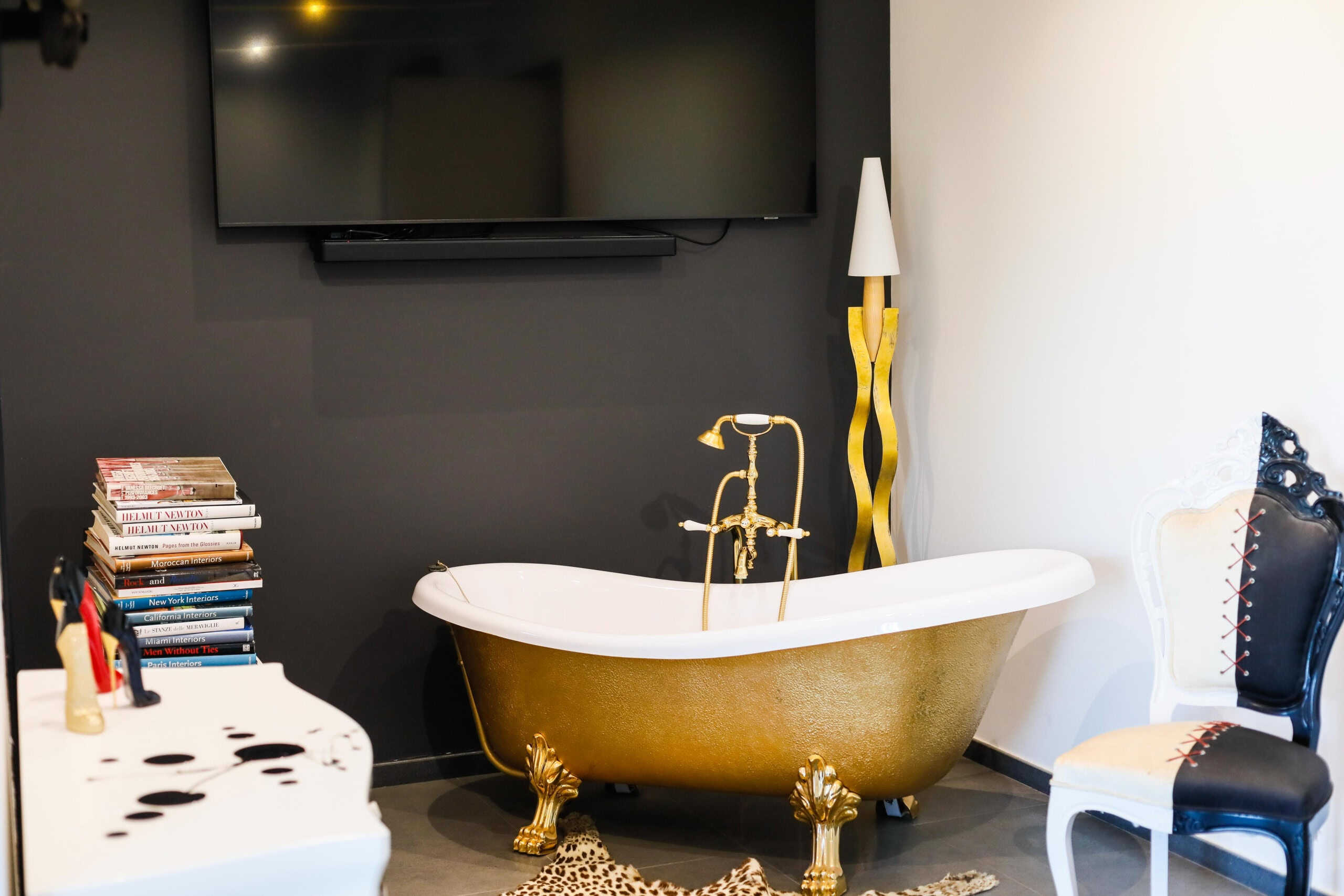 Vasca da bagno classica con finitura oro in ambiente modern-contemporaneo, decorata con accessori eleganti e complementi di design, perfetta per ambienti di lusso e stile raffinato.