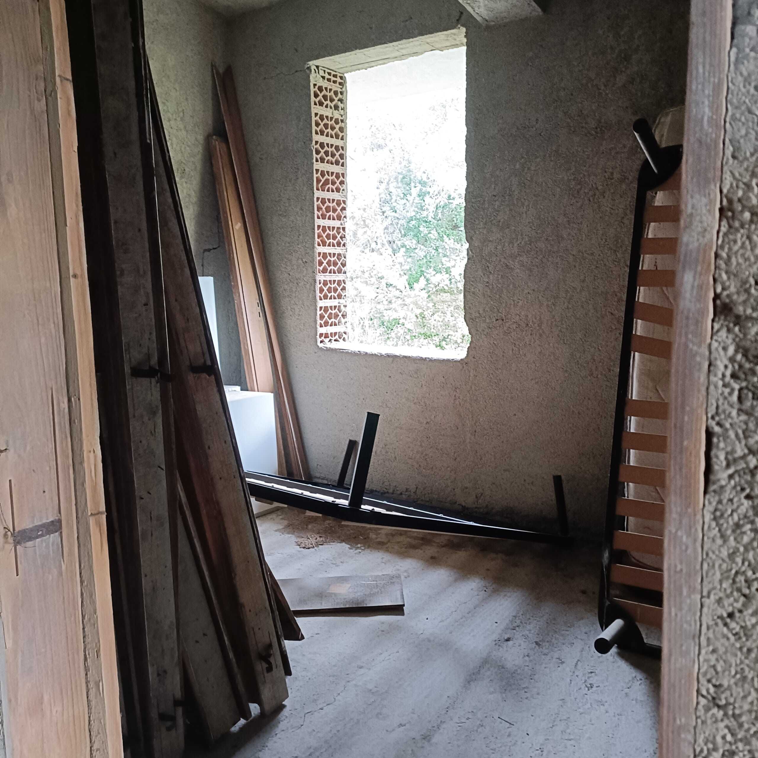 Ripresa di una stanza in costruzione con finestre senza vetri, materiali da costruzione e attrezzi per la ristrutturazione di interni casa.