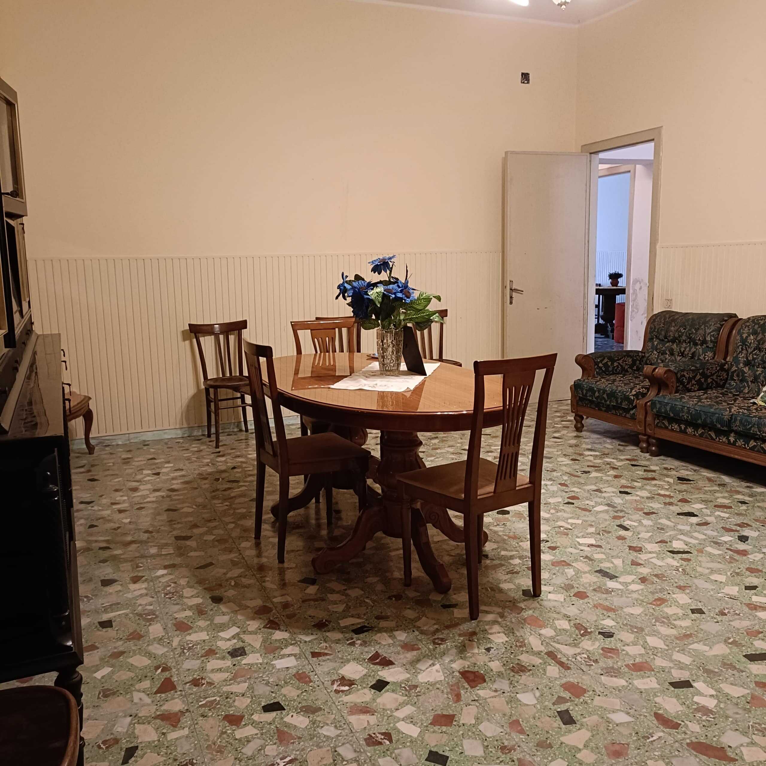 Sedie e tavolo in fermo stile classico, soggiorno con pavimento in mosaico colorato, arredamento tradizionale, ambiente accogliente e luminoso, ideale per vivere momenti di convivialità e relax, NextCasa.