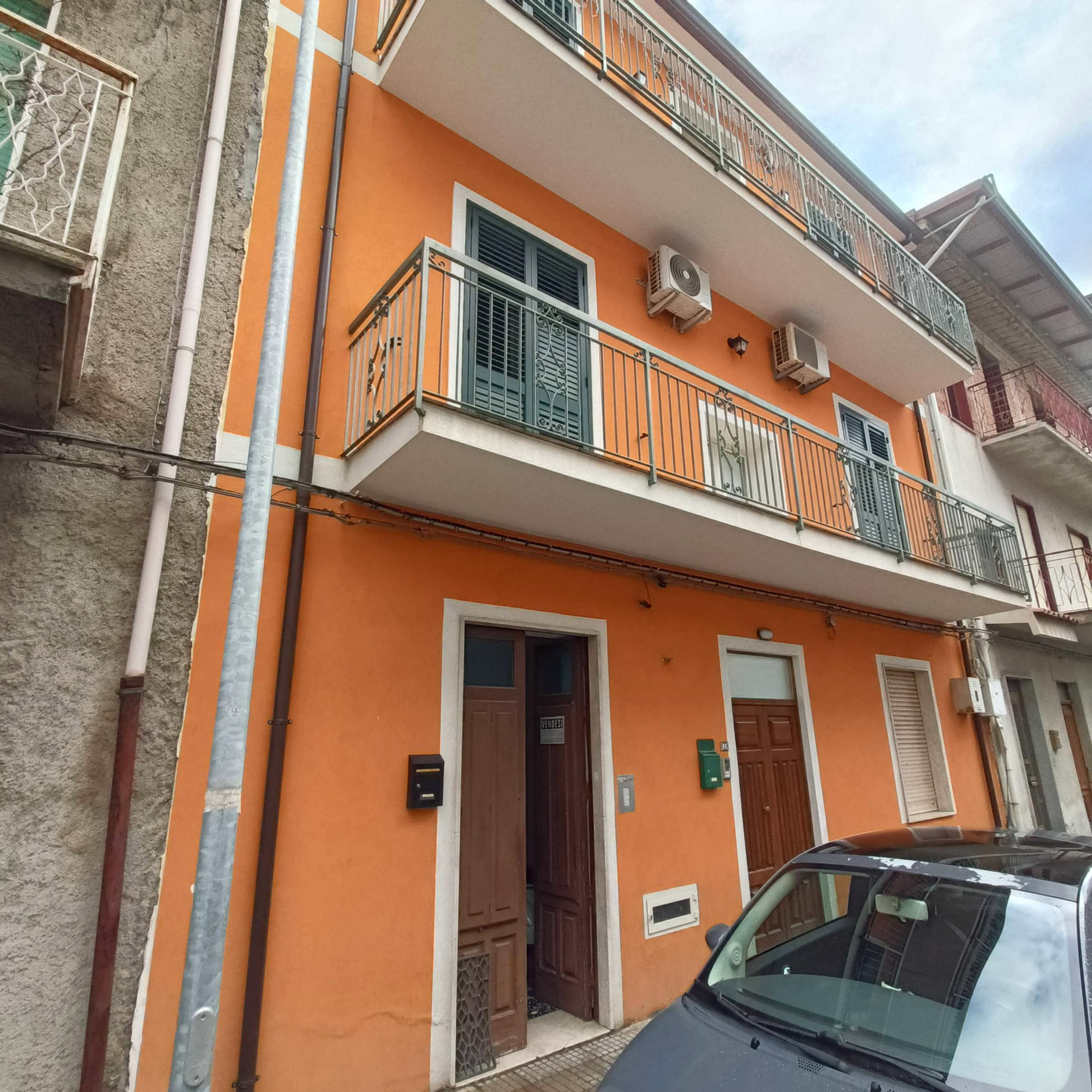 IMG20250113095216 Vila residenziale con facciata arancione, balconi in ferro battuto e aria condizionata, contesto urbano vicino a servizi e parcheggio, stile contemporaneo, ideale per investimento immobiliare.