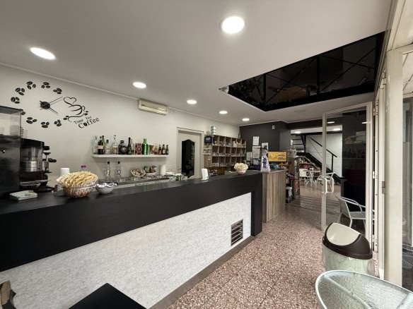 Bar caffetteria moderna con dettagli neri e decorazioni accoglienti, ideale per colazioni e pause durante la giornata, ambientazione luminosa e funzionale.
