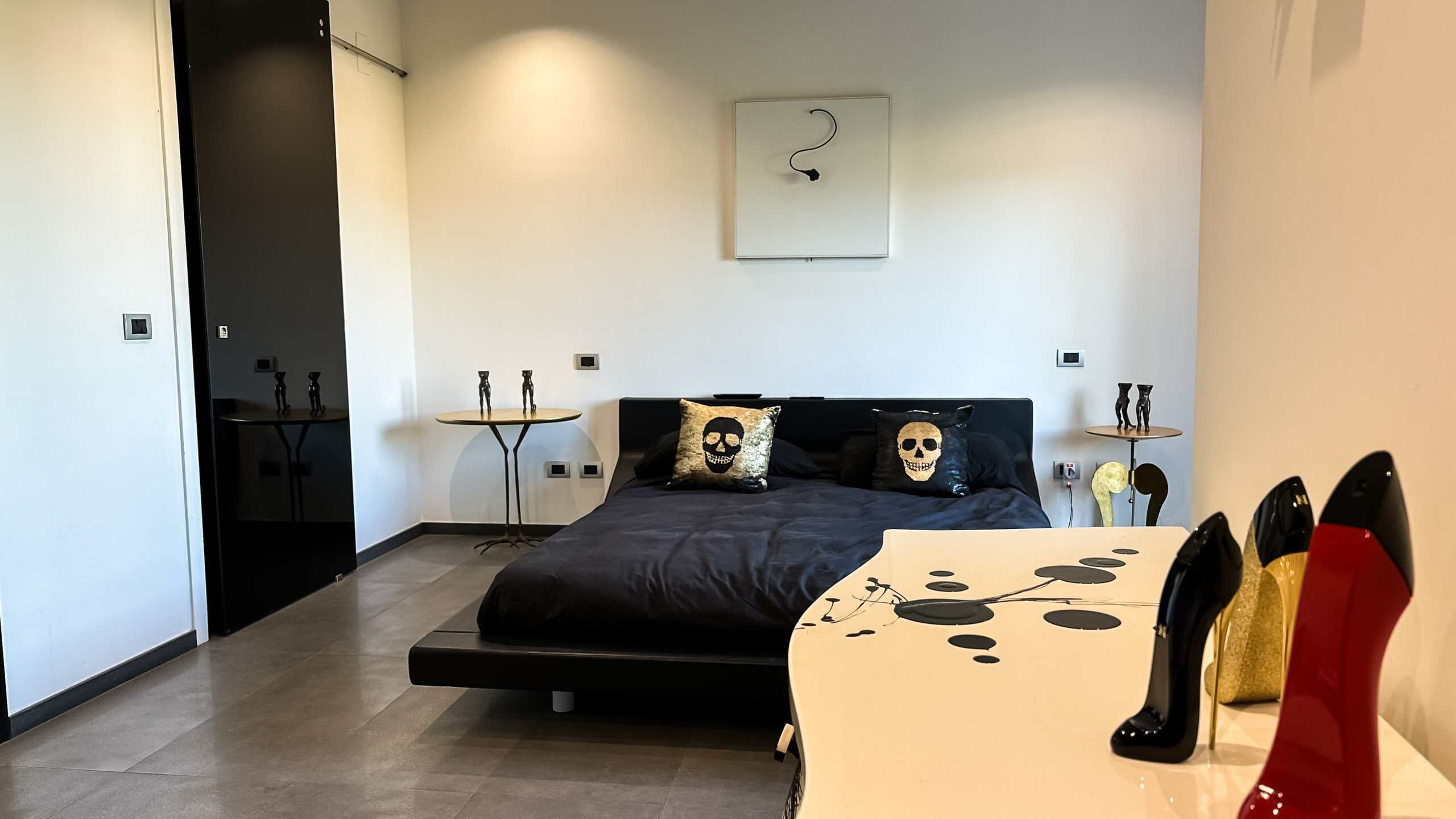Letto matrimoniale con cuscini decorativi a forma di skull in una camera moderna con arredi di design NextCasa, stile contemporaneo e dettagli eleganti per appartamenti di lusso.