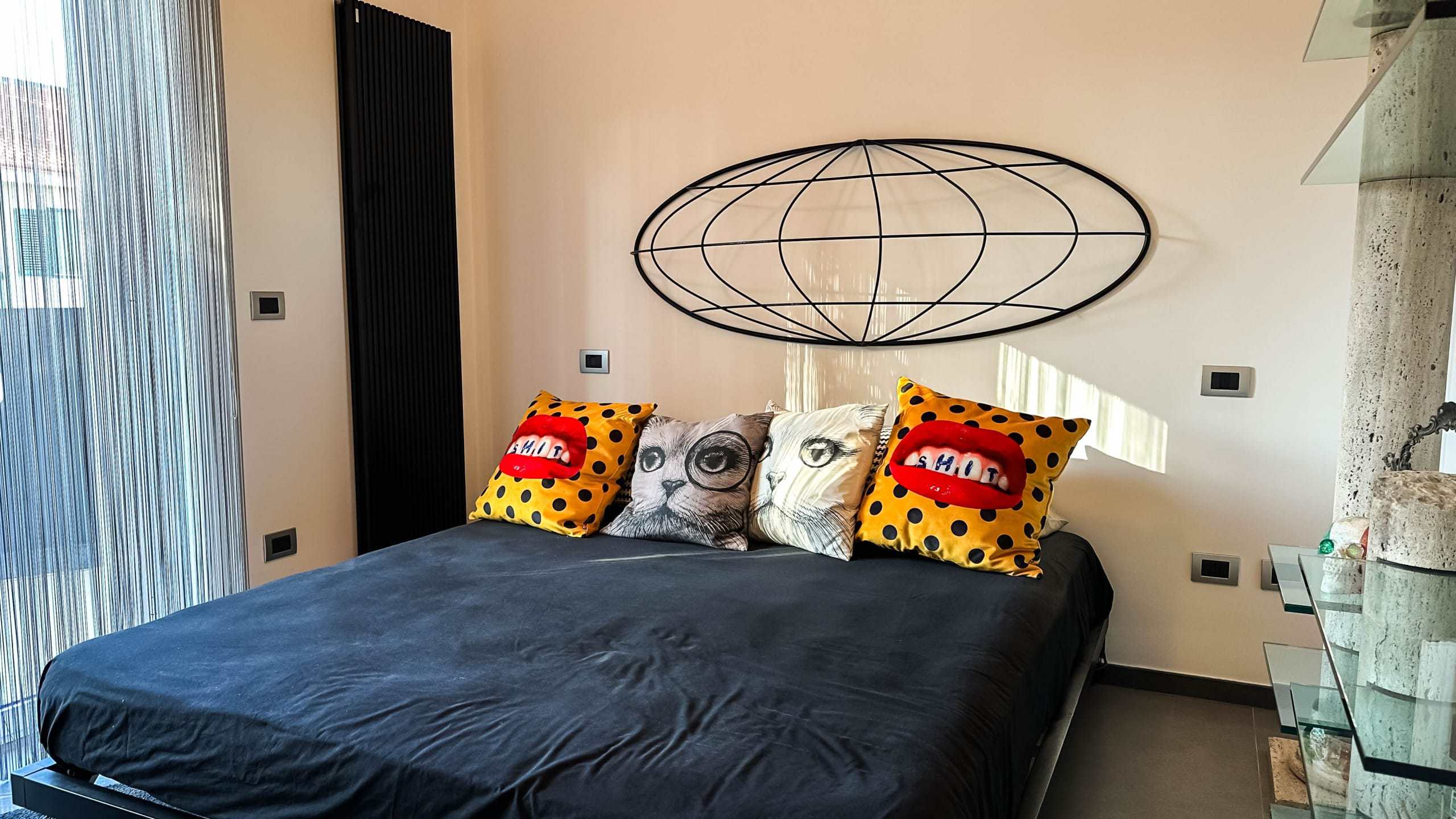 Lusso e design in un soggiorno moderno con parete decorativa, cuscini colorati e arredi eleganti, ideale per un'abitazione di alta qualità a Milano.