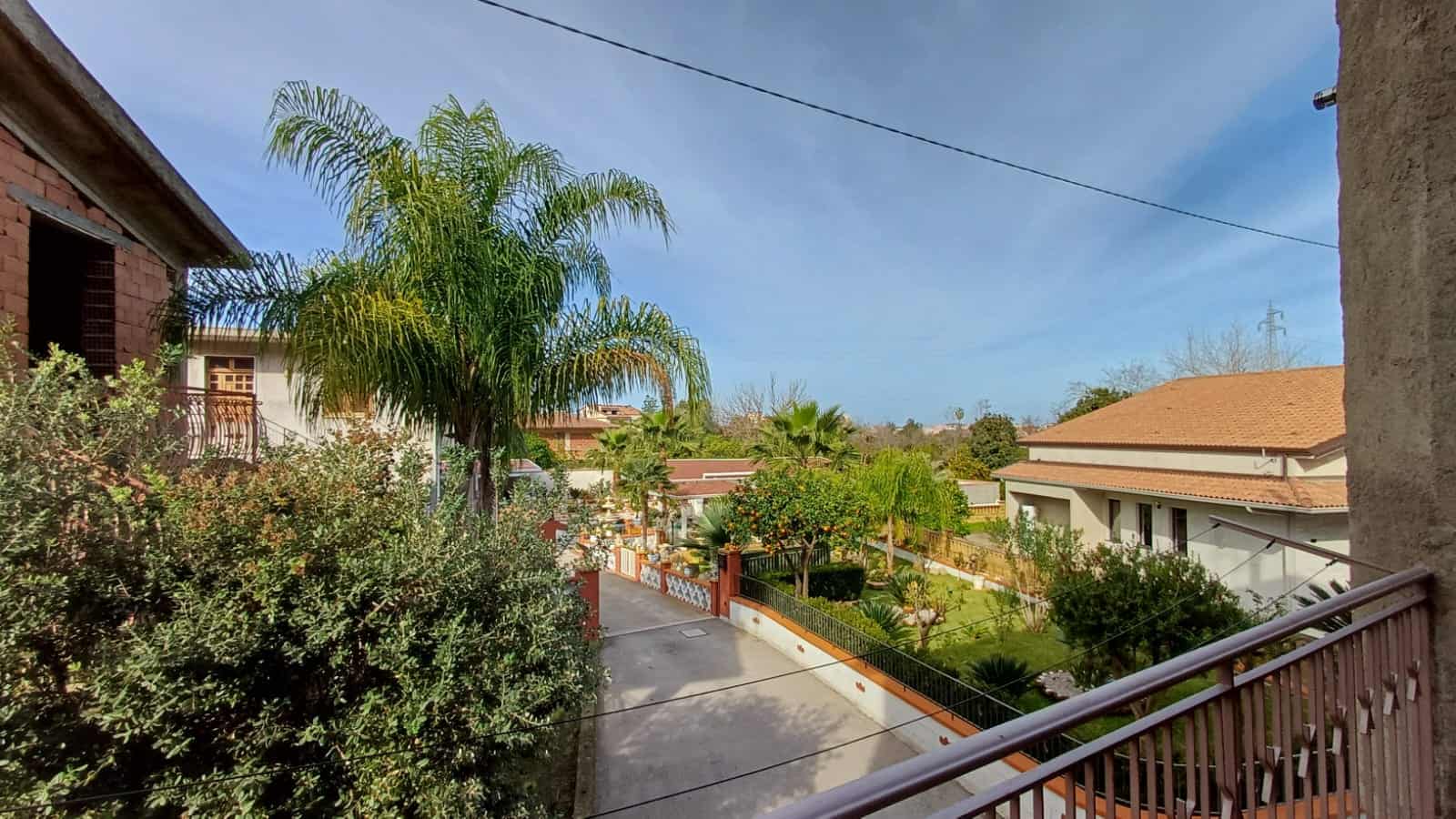 Palazzi e case con giardini e alberi nel quartiere residenziale di NextCasa, vista panoramica sul cielo e sulla natura circostante in un ambiente tranquillo e verde.