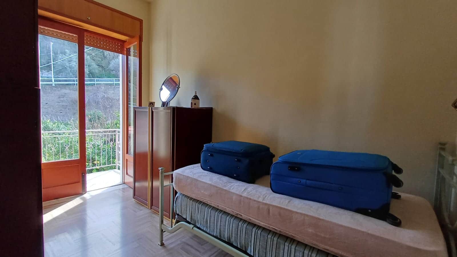 Bagno spazioso con balcone, luce naturale, vista esterna, arredamento semplice, accessori casa, porte a vetro, camera da letto, atmosfera accogliente, mobili funzionali, ambiente rilassante, stile minimalista, NextCasa.