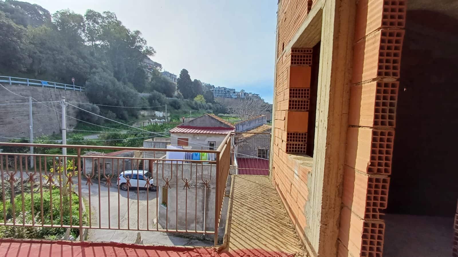 Affaccio su balcone con vista sulle case di montagna, ambiente tranquillo e rilassante, ideale per vivere in campagna o in periferia, vicino alla natura e alla tranquillità del territorio.