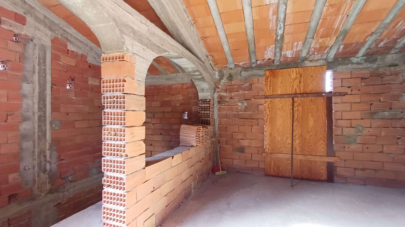 Mattoni rossi e cemento in costruzione, immobile in fase di ristrutturazione, lavoro edilizio, pareti interne non finite, che mostra uno spazio ancora in fase di sviluppo edilizio, immobile in costruzione NextCasa.