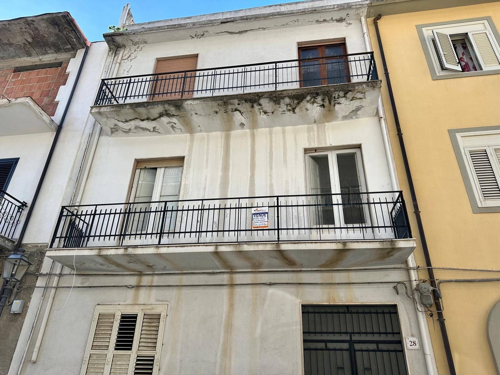 Villa in vendita con balconi e facciata da ristrutturare, situata in zona centrale, ideale per investimento immobiliare o abitazione privata, con potenziale di riqualificazione.